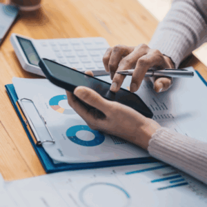 Smartphone in der Hand mit Statistiken auf dem Tisch – Fokus auf mobile UX