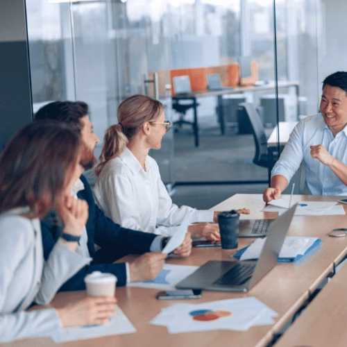Webdesign-Workshop bei HAI Strategies Kreatives Webdesign-Team im Meeting mit Analyse-Dokumenten und Laptops – HAI Strategies