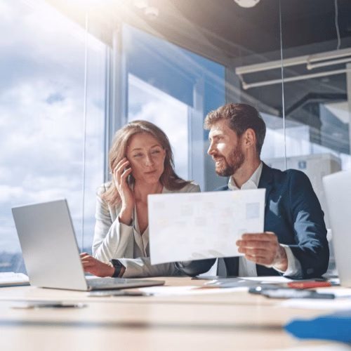 Strategische Webdesign-Planung bei HAI Strategies Zwei Webdesign-Profis analysieren Konzeptunterlagen am Laptop im modernen Büro – HAI Strategies