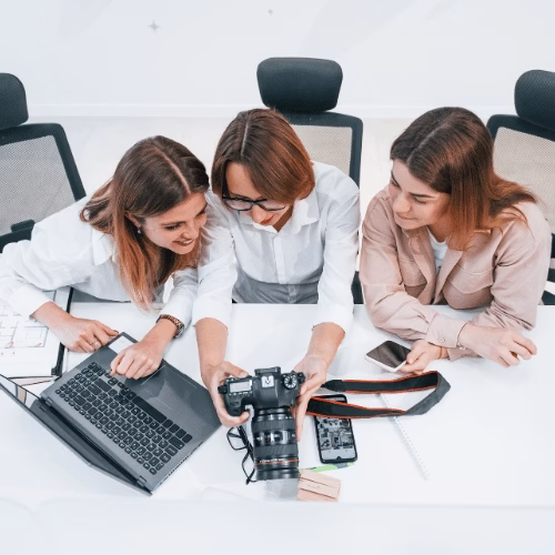 Kreative Content-Planung als Teil der Social Media Strategie Drei Social Media Spezialistinnen entwickeln Content-Ideen am Laptop und mit Kamera – HAI Strategies